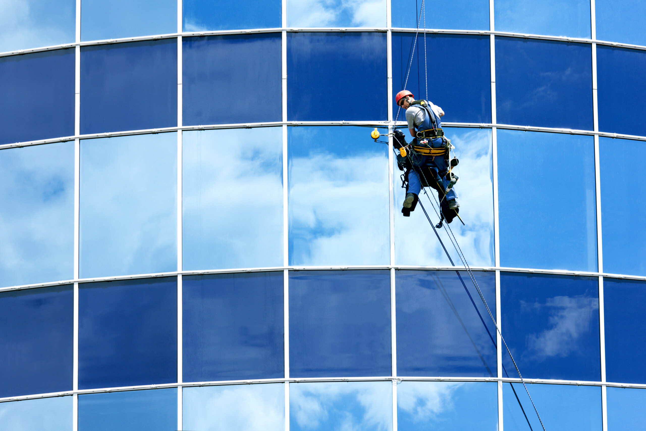 Homem realizando manutenção da fachada de um prédio